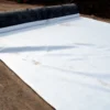 Filament Nonwoven Geotextile - 05 White filament nonwoven geotextile installed on prepared ground